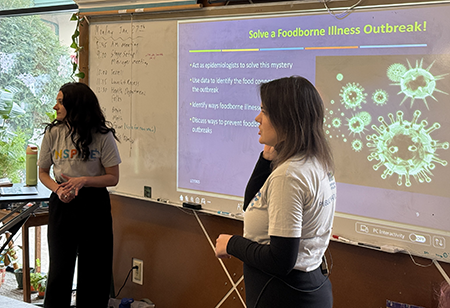 Two epidemiologists in front of classroom presenting