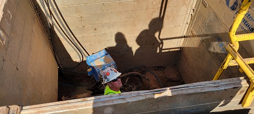 Worker in a trench to replace lead service line