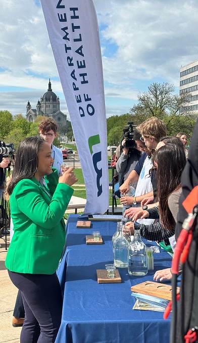 MDH commissioner Brooke Cunningham samples water during the event at the state capitol