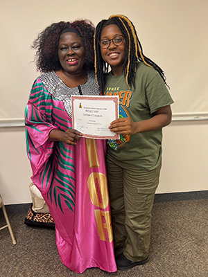 Two black women holding the BART certificate award.