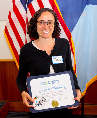 Cecilia Calabria of COPAL smiles and holds her certificate of recognition