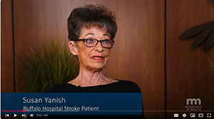 A woman with short brown hair, glasses and black top speaks to the camera